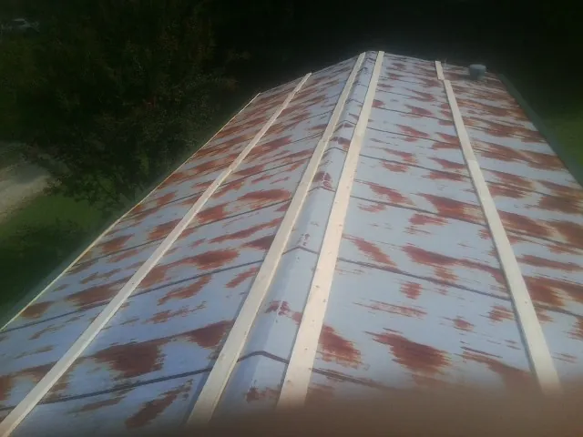 Rusted metal roof panels with new wood purlins before replacement — Storm Damage Roof Repair in Hooper by Roofing Brothers